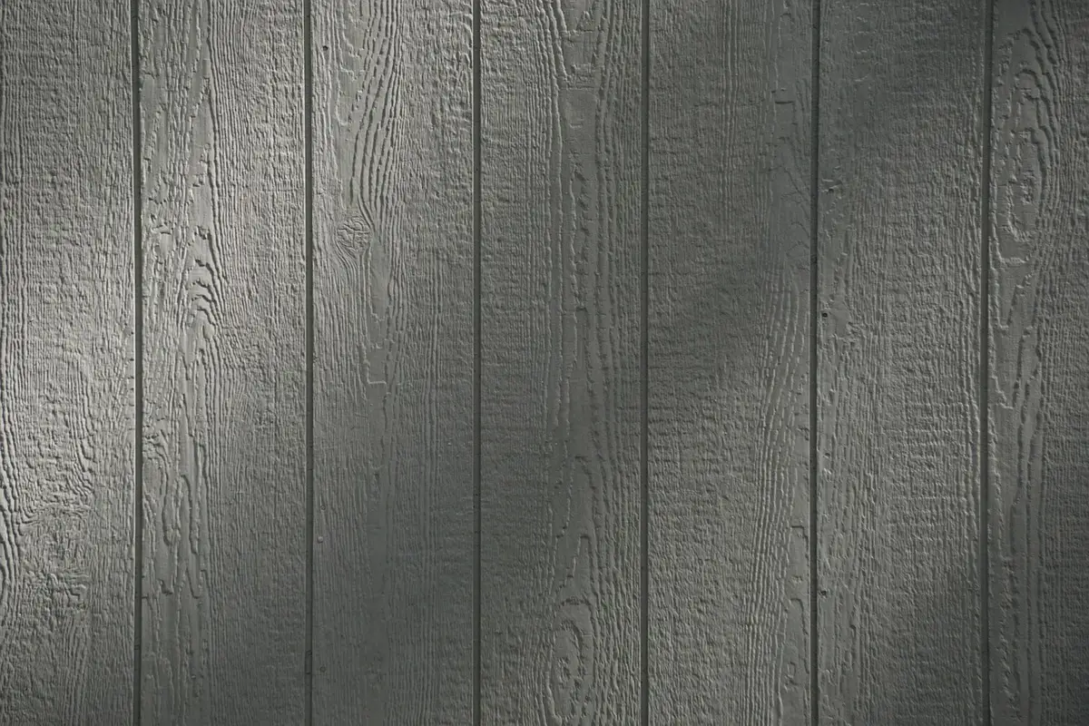 Close-up of vertical wooden cladding showing rain runoff on boards and a narrow ventilated cavity behind